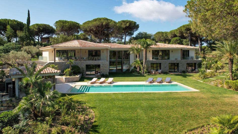 Landscape view of Villa B in St Tropez, with the infinity swimming pool in the foreground and the surrounding green nature. This is one of the best luxury villas in St Tropez.