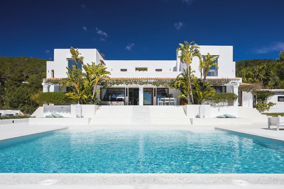 Landscape view of the externals of Villa El Zafiro, one of our best luxury villas in Ibiza, with the swimming pool in the foreground. 