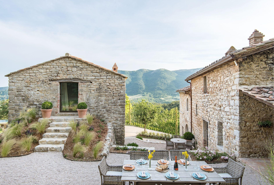 The main house and annexe of the beautiful Villa Penna in Umbria, features hillside views and an alfresco dining space to enjoy a self-catered villa holiday.