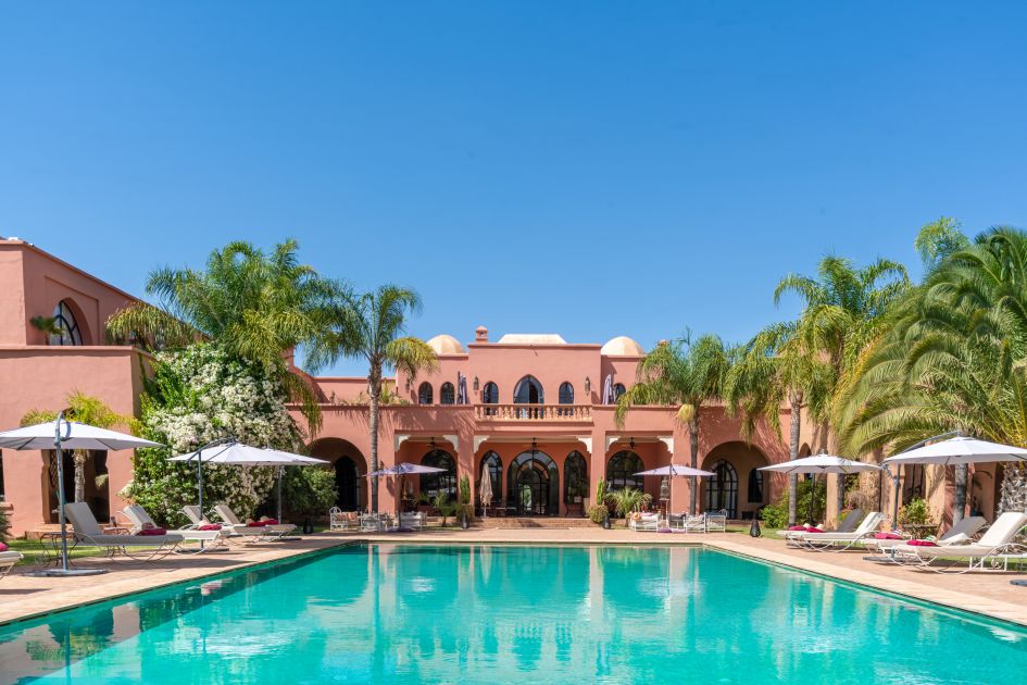 Landscape view of the super luxury villa, Palais Hassoun in Morocco, with the infinity swimming pool in the foreground.