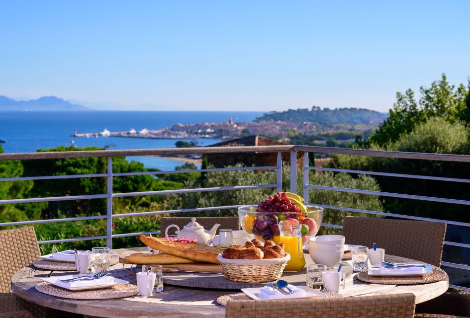 Panoramic view over St Tropez bay from the main terrace of Villa Rêve de Lumière, with a breakfast table picture on the foreground.