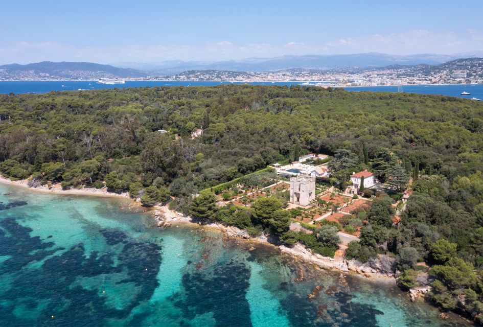 View over Le Grand Jardin expansive grounds, with the green nature of St Marguerite Island in the background. This is a lovely private luxury villa in Cannes.