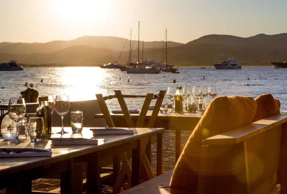 Relaxed restaurant settling at Bouillabaisse Beach with views of the ocean as the sun is setting