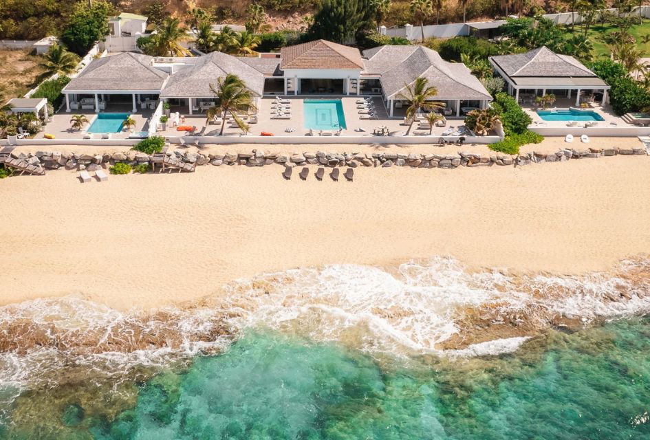 Drone shot of Villa La Perla Estate in St Martin, with the Caribbean Sea and Baie Rouge Beach in the foreground. 