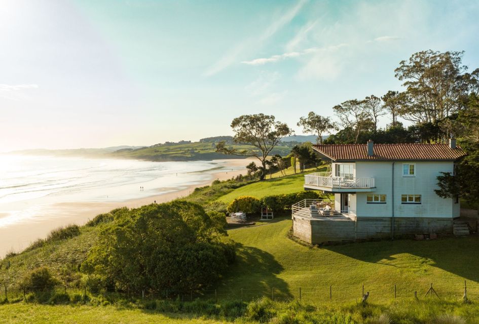 View of the stunning beach front villa in Cantabria, Villa Rumoroso, combining the green countryside, the golden shores of Oyambre Beach and the ocean.