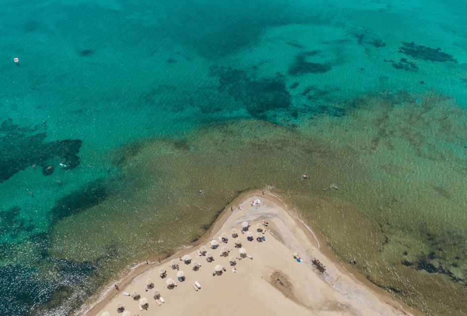 Drone view over a secluded beach in Antiparos, one of the best islands in Greece, surrounded by the turquoise waters of the Aegean Sea.