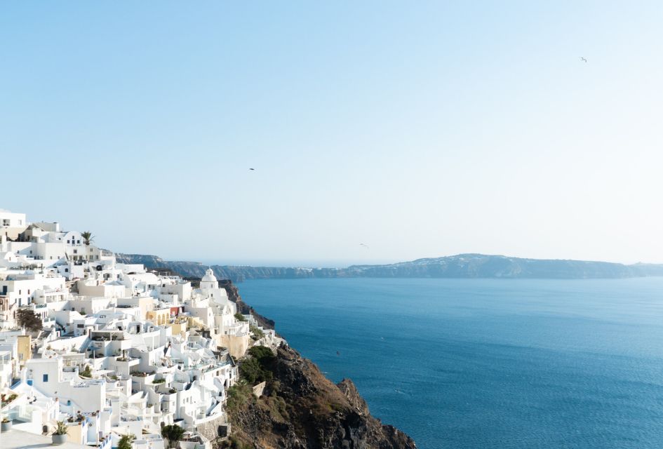 Whitewashed buildings of Santorini overlooking the blue waters of the Aegean Sea, hosting luxury Greek Island villas.